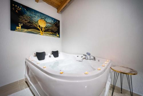 a white tub in a bathroom with a painting on the wall at KaşKalkan Honeymoon Villa with Seaview in Kalkan