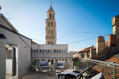 a balcony with chairs and a clock tower at Palace Penthouse with Terrace in Split Centre Old Town in Split