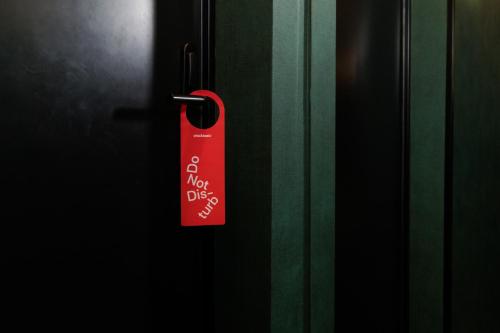 a red tag hanging on a door at chic&basic Gravity in Porto