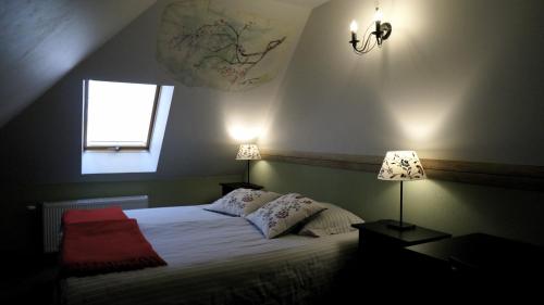 a bedroom with a bed with two pillows and a window at Zaku Krogs in Jūrkalne