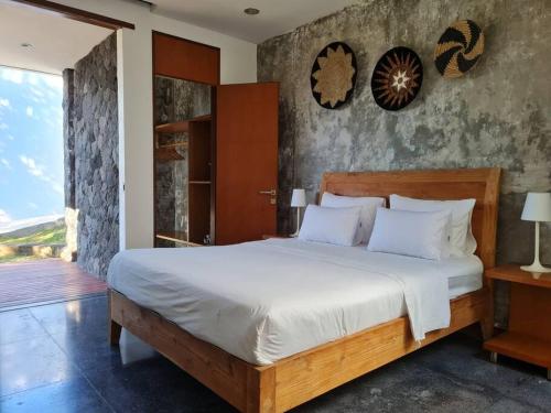 1 dormitorio con 1 cama grande y balcón en Villa Mila, en Dalung