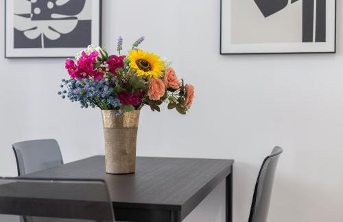 a vase of flowers sitting on top of a table at La La Suites Rianal in Jerez de la Frontera