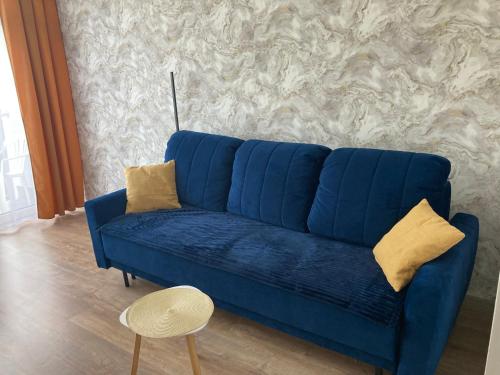 um sofá azul com almofadas amarelas numa sala de estar em Lemon em Ustroń