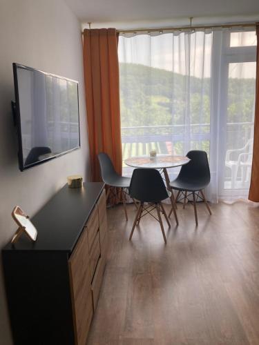 uma sala de estar com uma mesa e cadeiras e uma televisão em Lemon em Ustroń