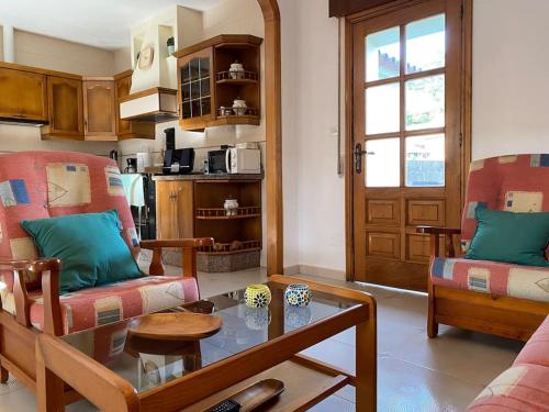 sala de estar con 2 sillas y mesa de cristal en Playa, Jardín y piscina en Cabo Udra en Pontevedra