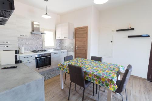 une cuisine avec une table et des chaises dans une pièce dans l'établissement Apartment Lo Duca, à Cefalù