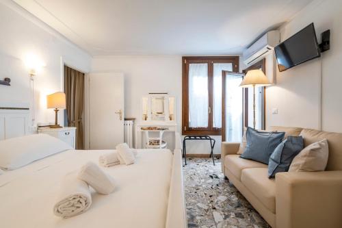 a living room with a bed and a couch at Appartamento ai Miracoli in Venice