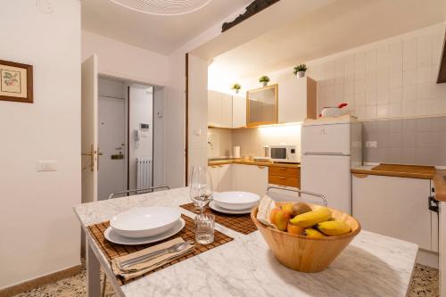 a kitchen with a table with a bowl of fruit on it at Appartamento ai Miracoli in Venice