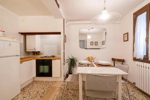 a kitchen with a table and a white refrigerator at Appartamento ai Miracoli in Venice