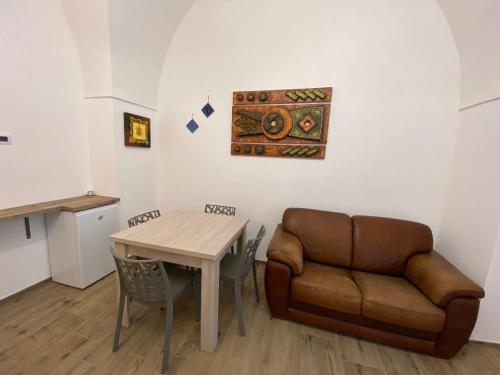 un soggiorno con divano e tavolo di B&B Leoncavallo a Grottaglie