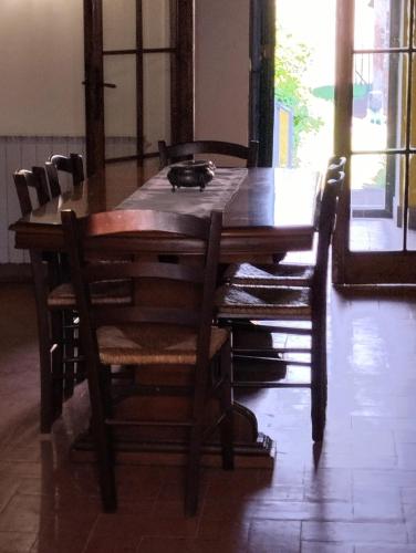 a wooden table with chairs and a cat sitting on top at ROSMARINO CASALE in Città della Pieve