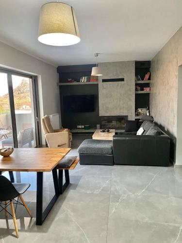 ein Wohnzimmer mit einem Sofa und einem Tisch in der Unterkunft Eleusis luxury flat in Eleusis