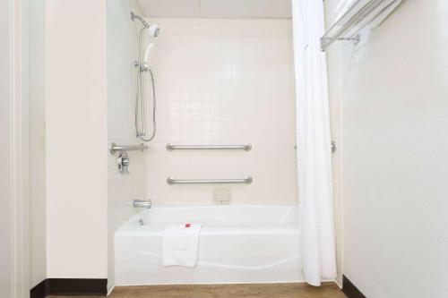 a bathroom with a white tub and a shower at Days Inn by Wyndham Harrisburg North in Harrisburg