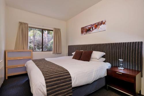 a bedroom with a large bed and a window at Lantern 1 Bedroom Balcony with amazing view in Thredbo