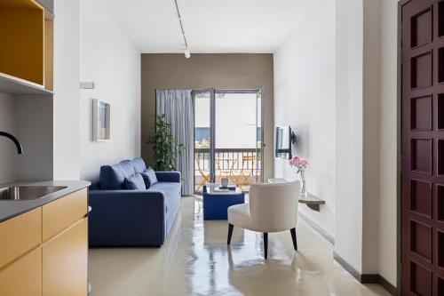 ein Wohnzimmer mit einem blauen Sofa und einem Tisch in der Unterkunft Nileos House in Athen