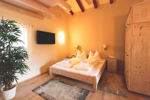 a bedroom with a bed and a tv on the wall at Alpenlandhaus Menardi in Seefeld in Tirol