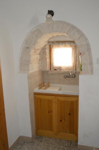 łazienka z umywalką i oknem w obiekcie Trullo Pugliese w Alberobello