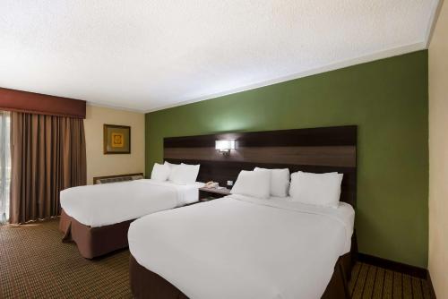 2 camas en una habitación de hotel con paredes verdes en Best Western Prairie Inn & Conference Center, en Galesburg