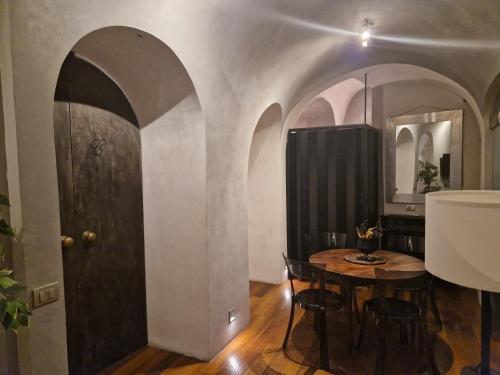 een eetkamer met een tafel en een zwarte deur bij Domus Ciancaleoni - Colosseum - Rione Monti in Rome