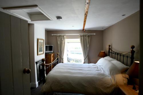 a bedroom with a bed and a window at Holmlea Cottage in Mickleton