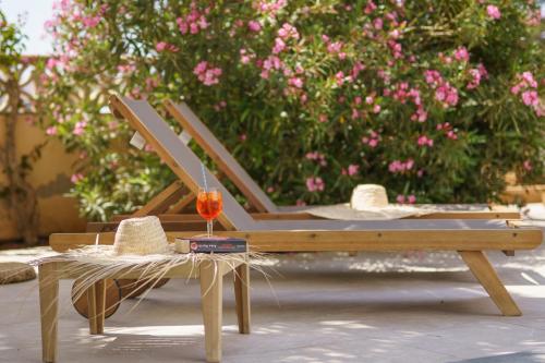 a wooden bench with a table and a glass of wine at Apartaments Andreas in Colonia Sant Jordi