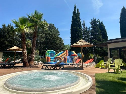 a swimming pool with chairs and a swimming pool at Le Chalet de Louise 7 places in Taradeau