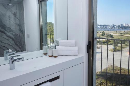 a bathroom with a sink and a window with a view at Porto sunset suite in Vila Nova de Gaia