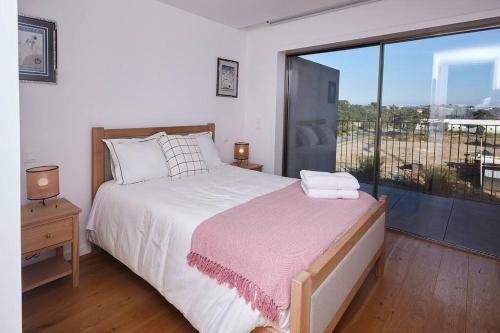 a bedroom with a bed and a large window at Porto sunset suite in Vila Nova de Gaia