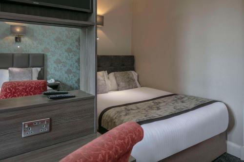 a hotel room with two beds and a mirror at Sure Hotel by Best Western Lockerbie in Lockerbie