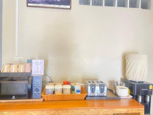 a counter top with a microwave and a coffee maker at Bluegelatohousekohtao in Ko Tao