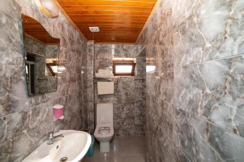 a bathroom with a sink and a toilet at Yakamoz Hotel Gökçeada in Gokceada Town