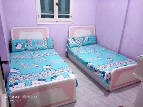 2 bedden in een kamer met paarse muren bij رأس البر in Ras El Bar