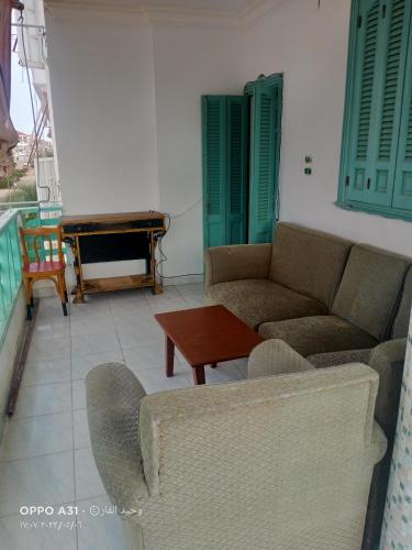 een woonkamer met banken en een tafel en een piano bij رأس البر in Ras El Bar