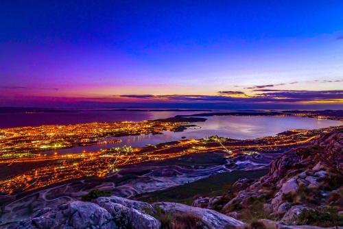 a view of a city from a mountain at night at Palace Penthouse with Terrace in Split Centre Old Town in Split