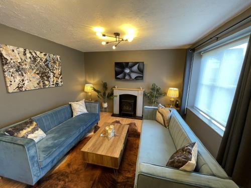 un soggiorno con divano blu e tavolo di No50 - 2-bed Boutique Apartment - Hosted by Hutch Lifestyle a Leamington Spa