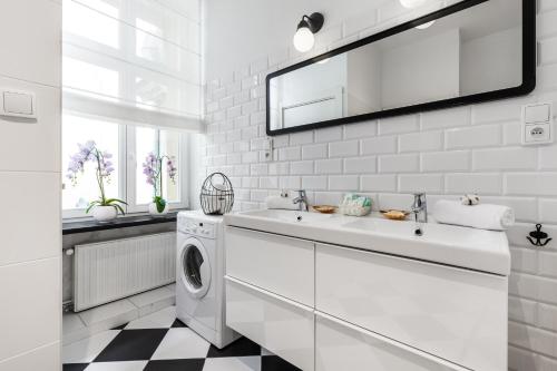 een witte badkamer met een wastafel en een wasmachine bij Happy Stay Sopot Monte Cassino 44 B in Sopot