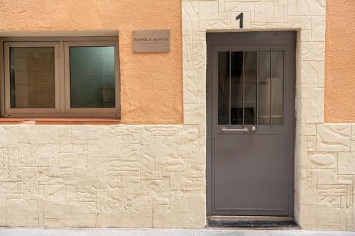 a building with a gray door and a window at Rambla de Mar Apartments by Blossom Hotels in Barcelona