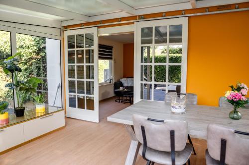 a dining room with a table and chairs at Familie bungalow op vakantiepark bij zee in Baarland