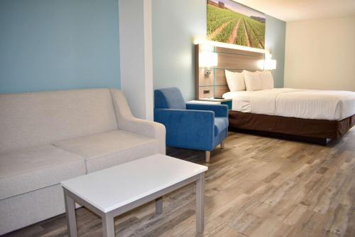 a hotel room with a couch and a bed at Clarion Pointe Vidalia - Lyons West in Vidalia