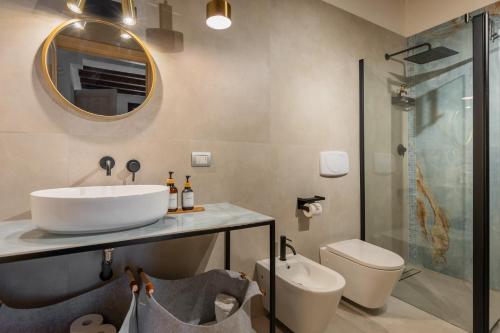 a bathroom with a sink and a toilet and a mirror at Osvaldo - parcheggio e giardino privato in San Giovanni in Persiceto