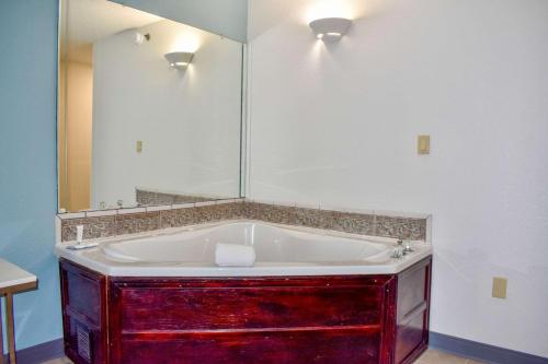 a bathroom with a tub with a large mirror at Clarion Pointe Vidalia - Lyons West in Vidalia
