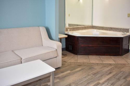 a living room with a couch and a bath tub at Clarion Pointe Vidalia - Lyons West in Vidalia