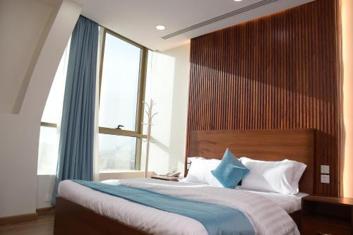 een slaapkamer met 2 bedden en een groot raam bij فندق ايلاف الشرقية 2 Elaf Eastern Hotel 2 in Sayhāt