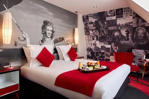 Pokój hotelowy z dużym łóżkiem z czerwonym kocem w obiekcie Platine Hotel w Paryżu