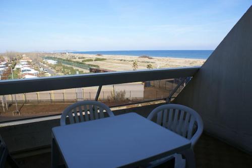 d'un balcon avec une table et une vue sur la plage. dans l'établissement Studio 340, Héliopolis AB au village naturiste, au Cap d'Agde