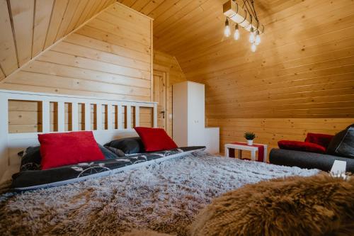 a bedroom with a large bed with red pillows at Domek drewniany - Czerwienne in Czerwienne