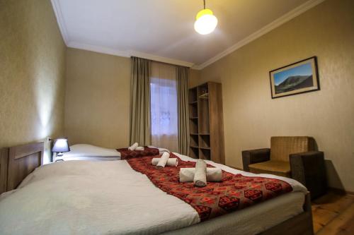 a bedroom with a large bed and a chair at house by the river in Mestia