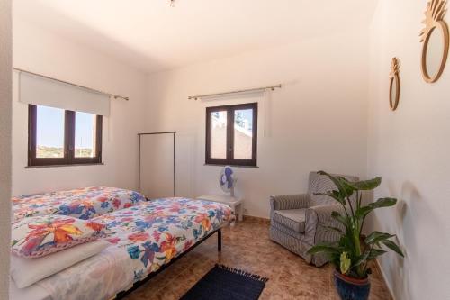 a bedroom with a bed and a chair at Villa Principezinho in Portimão