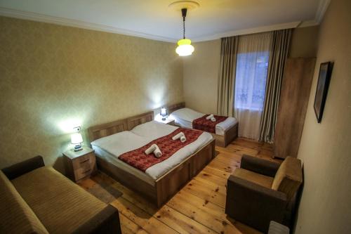a hotel room with two beds and a couch at house by the river in Mestia