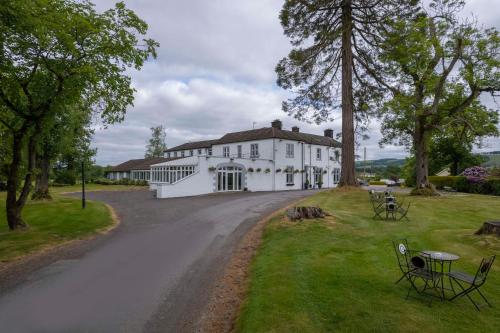 a large white house with a road in front of it at Dryfesdale Hotel - BW Signature Collection in Lockerbie